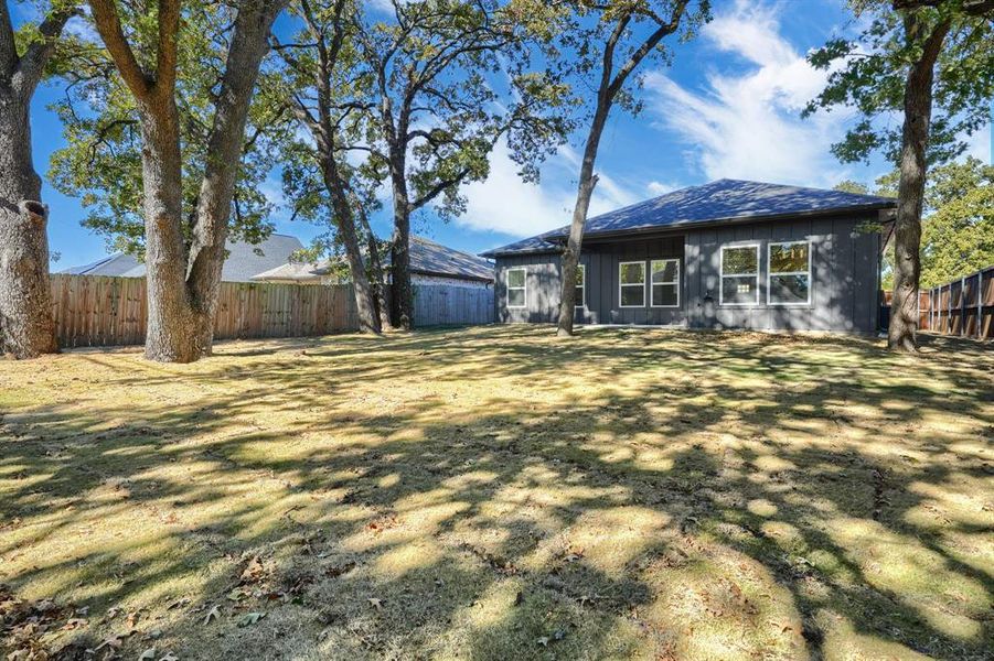 Rear view of house featuring a fenced backyard and board and batten siding