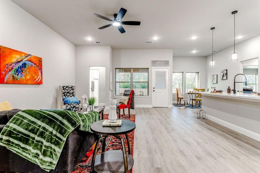 Living room with light hardwood / wood-style floors, ceiling fan, and sink