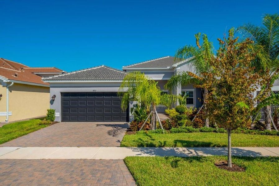 Front exterior of a new home in Valencia Del Sol, Wimauma, FL, highlighting curb appeal (Image 2). Front exterior of a new home in Valencia Del Sol, Wimauma, FL, highlighting curb appeal (Image 2).
