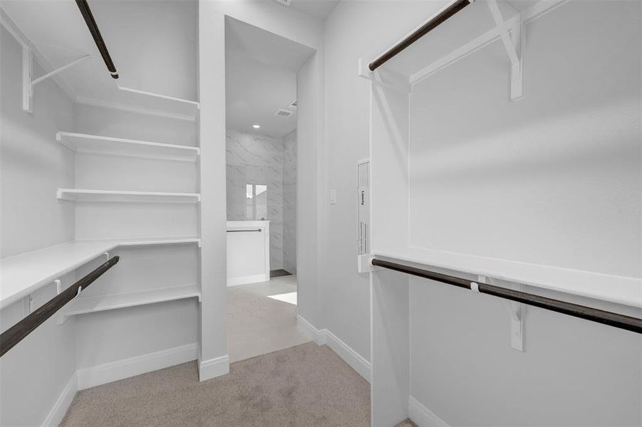 Walk in closet featuring light colored carpet Walk in closet featuring light colored carpet