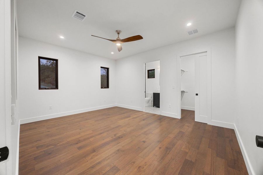 Spacious room featuring wide plank wood-finish flooring, recessed lighting, and a ceiling fan