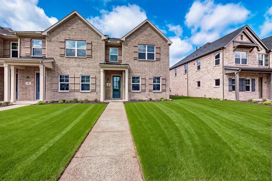 View of front of property featuring brick siding and a front lawn