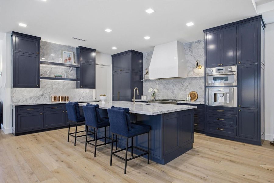 At the center, a statement island offers both function and presence—perfectly scaled for gathering, dining, and everyday living.