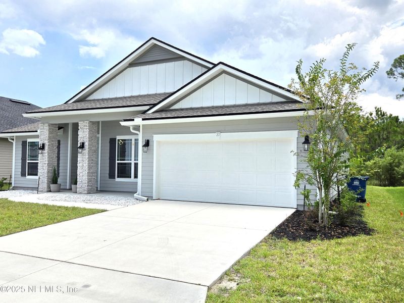 Front exterior of a new home in Sandy Creek, St. Augustine, FL, highlighting curb appeal (Image 1).