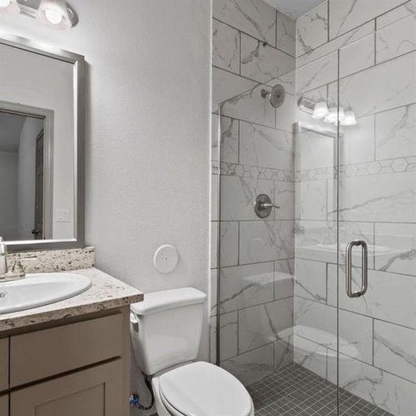 Secondary bath featuring an elegant glass frame walk in shower. **This image is from another Saratoga Home with similar floor plan - Myrtle Floorplan.**