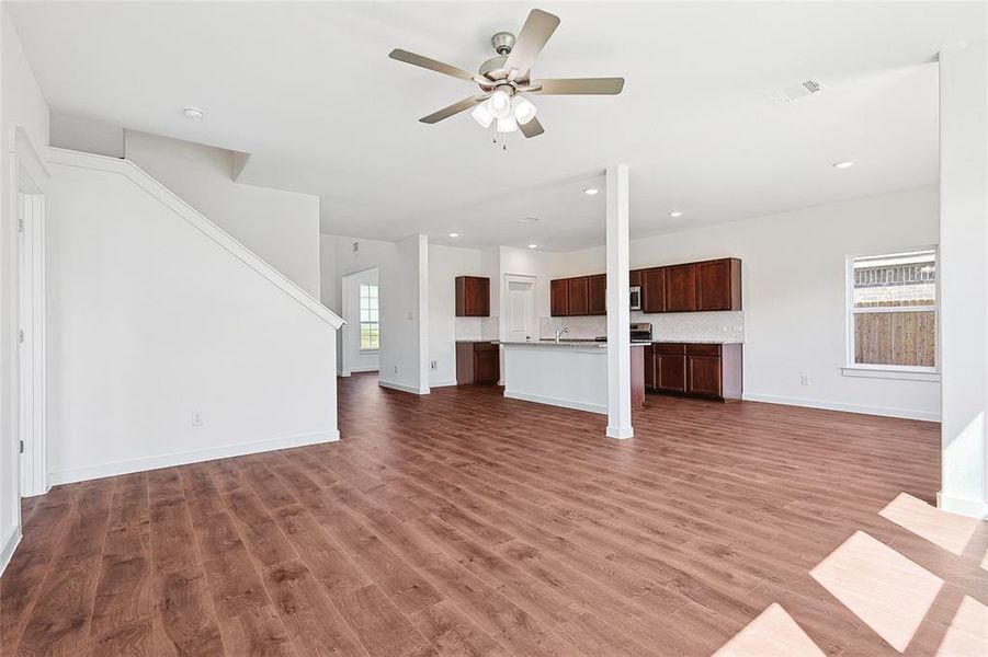 Unfurnished living room featuring a ceiling fan, dark wood finished floors, and recessed lighting