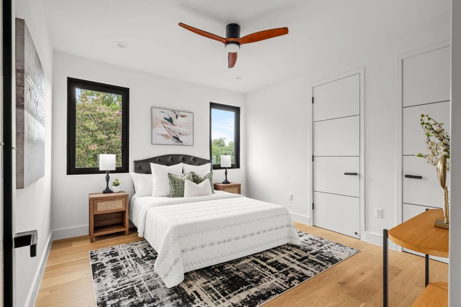 Hardwood floors and a ceiling fan enhance this naturally lit bedroom, offering peaceful views of the outdoors. Hardwood floors and a ceiling fan enhance this naturally lit bedroom, offering peaceful views of the outdoors.