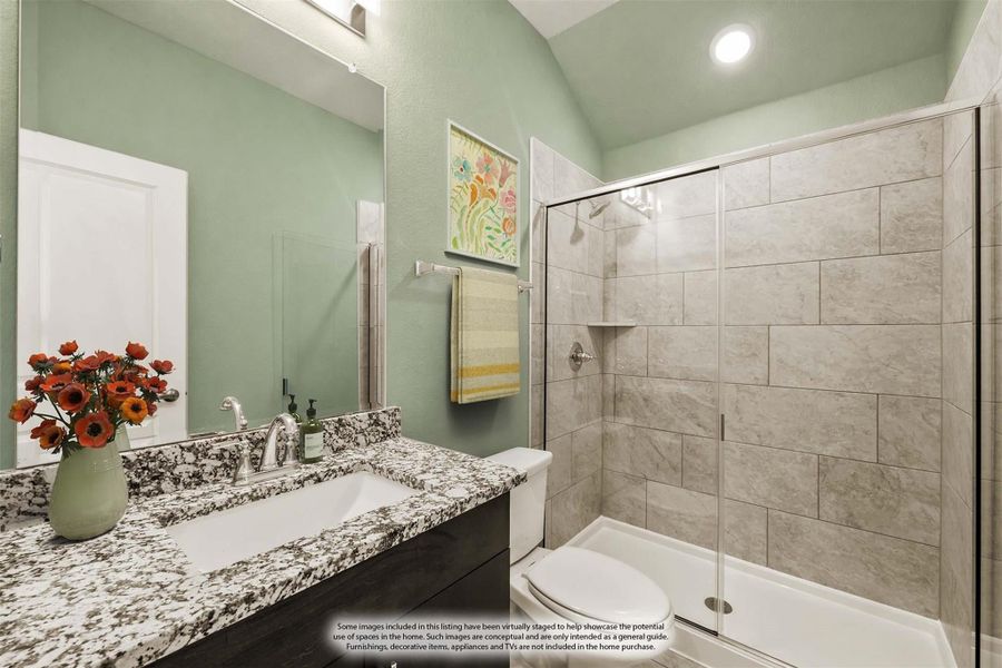 Bathroom with granite vanity, glass walk-in shower with tile surround, and vaulted ceiling with green walls