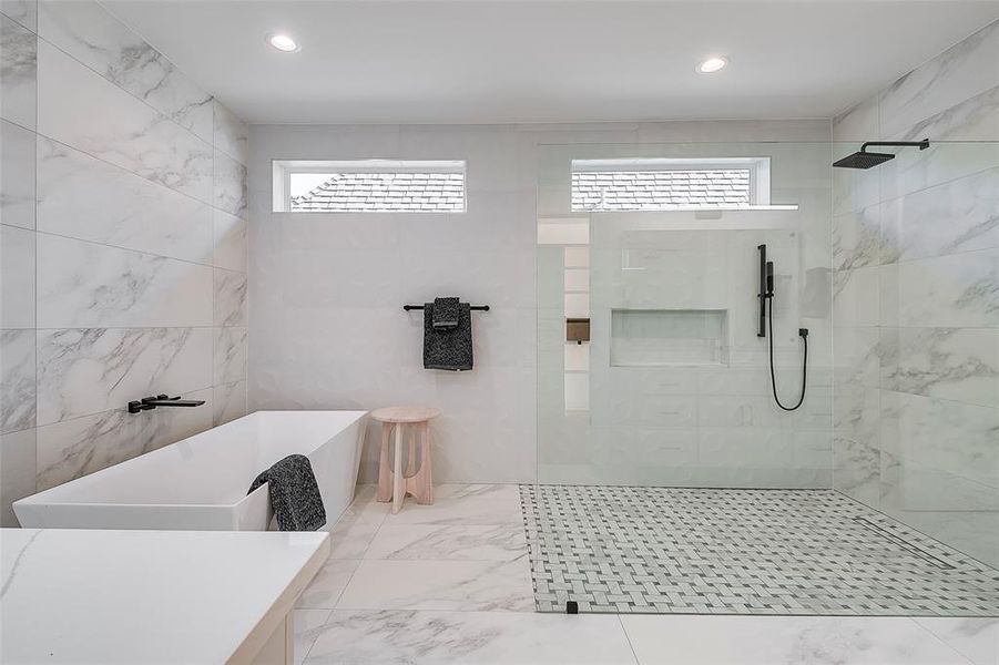 Bathroom featuring plenty of natural light and independent shower and bath