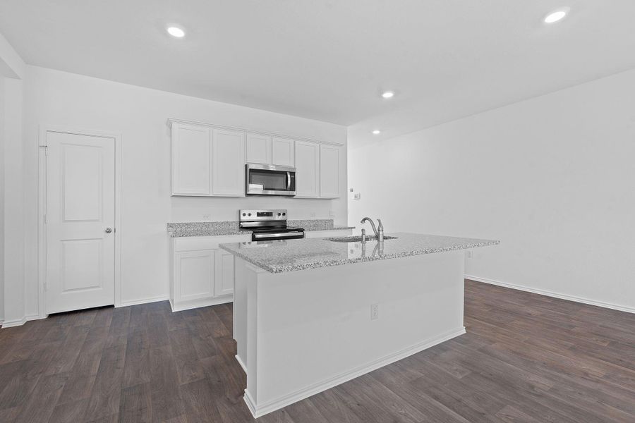 Kitchen with white cabinetry, stainless steel appliances, light stone counters, dark wood-type flooring, and recessed lighting Kitchen with white cabinetry, stainless steel appliances, light stone counters, dark wood-type flooring, and recessed lighting