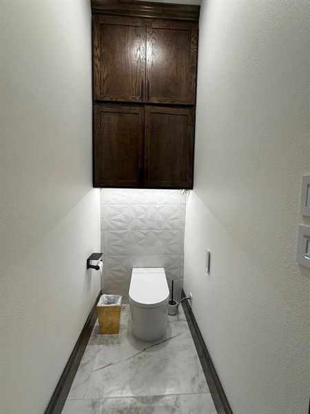 Bathroom with a textured wall and toilet