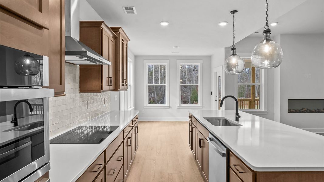 Highly skilled craftsmanship shines in this modern, gourmet kitchen with pendant lighting and a central island focal point