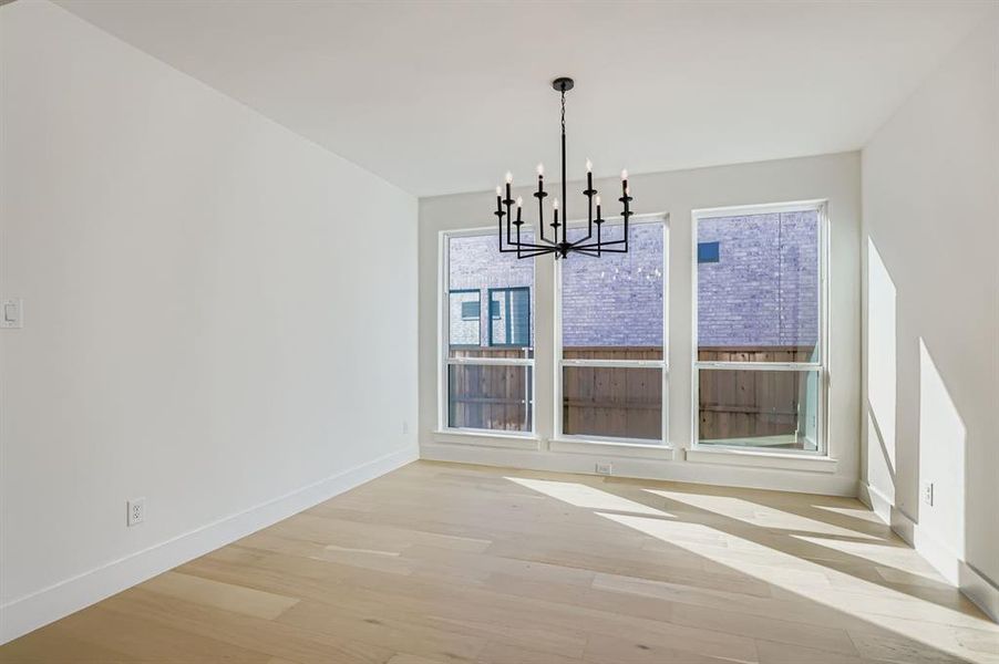 Unfurnished dining area with a chandelier and light wood-style floors