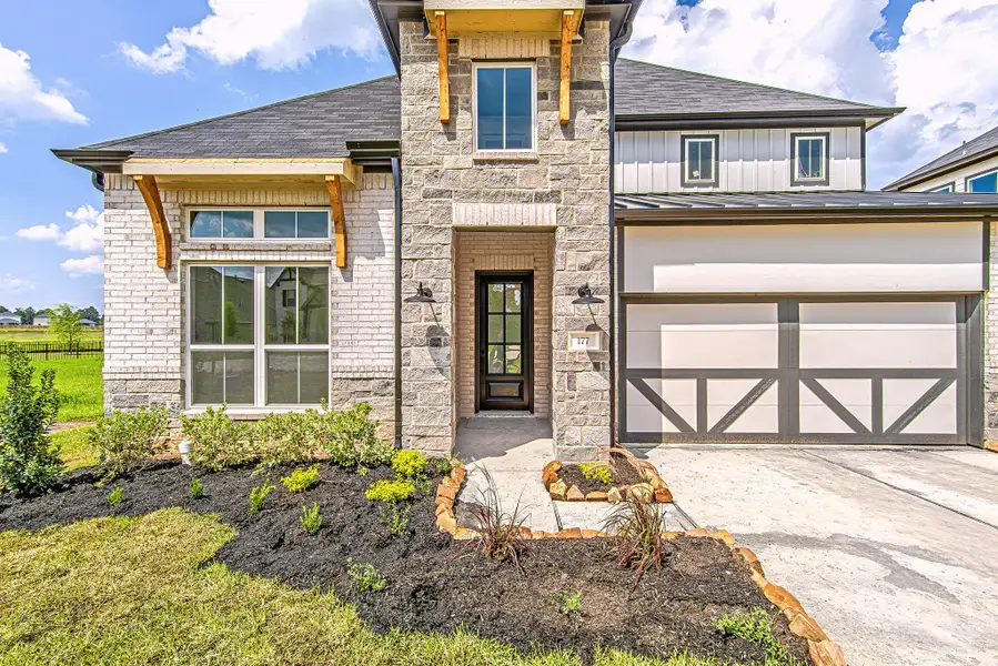 A welcoming front entryway framed by stone columns and custom wood corbels creates a bold yet inviting first impression. A welcoming front entryway framed by stone columns and custom wood corbels creates a bold yet inviting first impression.