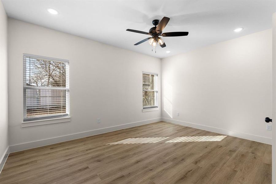 Spare room with wood-type flooring, a healthy amount of sunlight, and ceiling fan