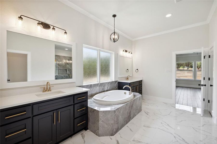 Bathroom with tile patterned flooring, double vanity, crown molding, and a relaxing tiled tub