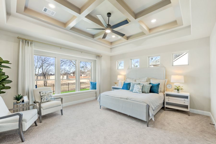 Large master bedroom with coffered ceiling, ceiling fan, king bed, and large windows with backyard view Large master bedroom with coffered ceiling, ceiling fan, king bed, and large windows with backyard view