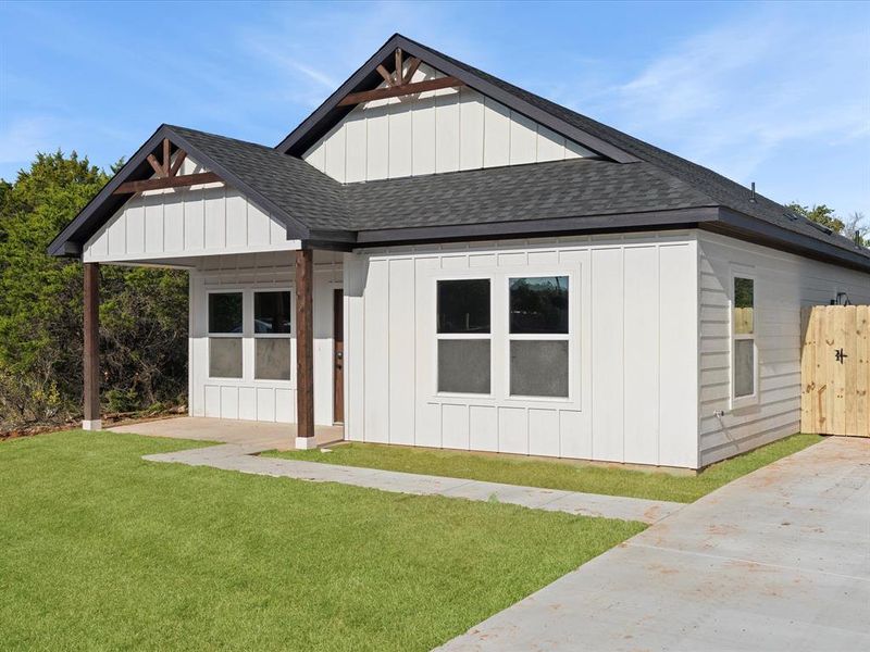 Modern inspired farmhouse with a shingled roof, board and batten siding, and a front lawn Modern inspired farmhouse with a shingled roof, board and batten siding, and a front lawn
