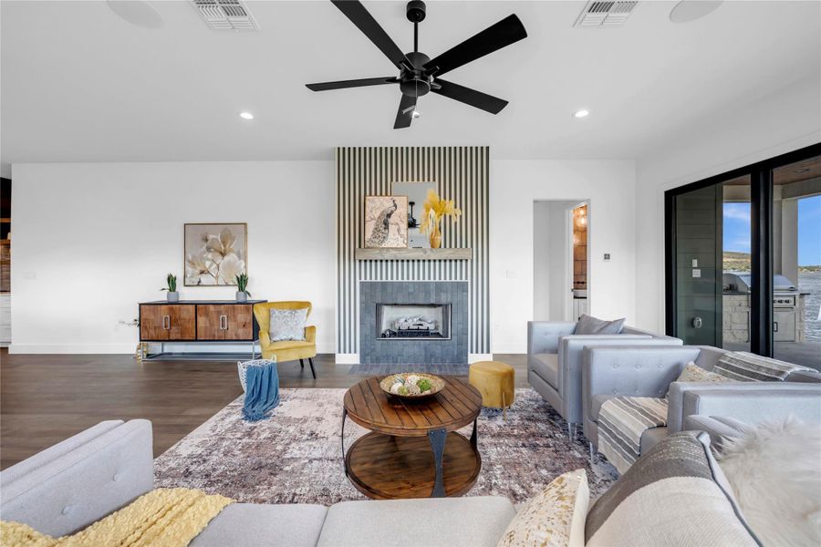 Living area featuring a fireplace, wood finished floors, recessed lighting, and ceiling fan