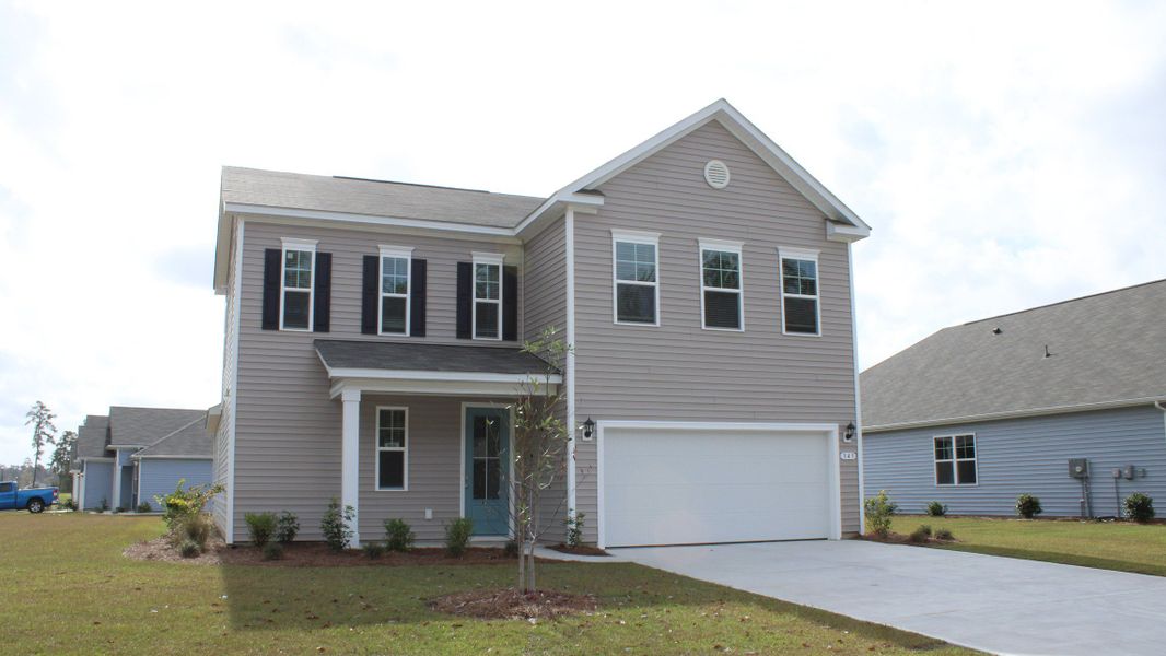 Front exterior of a new home in Brunswick Plantation, Ash, NC, highlighting curb appeal (Image 2). Front exterior of a new home in Brunswick Plantation, Ash, NC, highlighting curb appeal (Image 2).