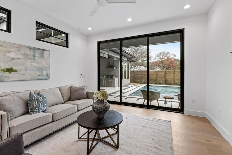 Living room with a ceiling fan, wood finished floors, recessed lighting, and baseboards