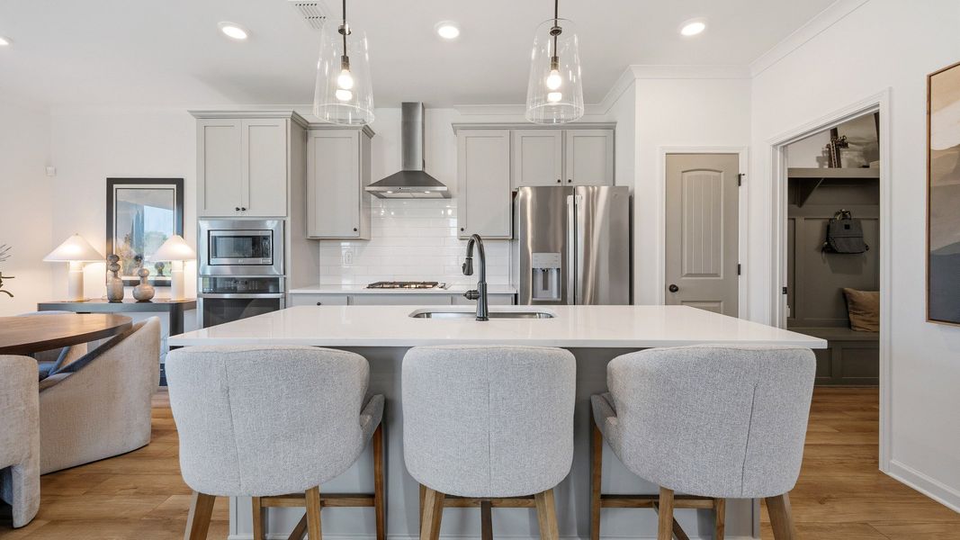 Spacious kitchen with center island and stylish cabinetry in Langley Overlook new construction townhome in Loganville, GA.