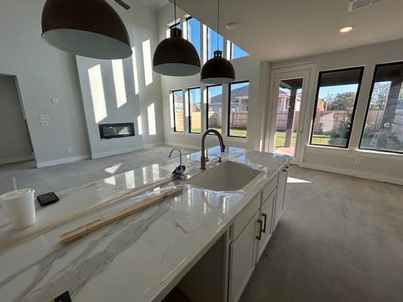 Kitchen is close to completion and offers porcelain counters, pendent lighting, and single bowl silgranite sink.