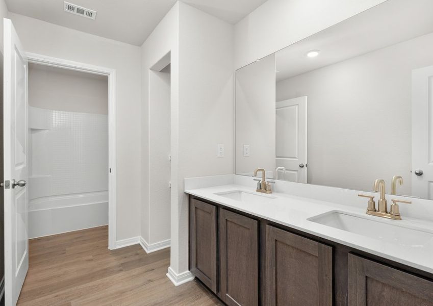 The secondary bathroom has a large vanity space and a shower-tub combo. The secondary bathroom has a large vanity space and a shower-tub combo.
