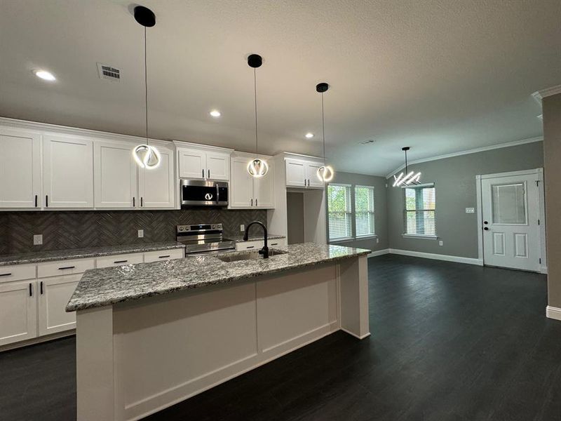 Kitchen featuring dark hardwood / wood-style floors, white cabinetry, sink, and appliances with stainless steel finishes