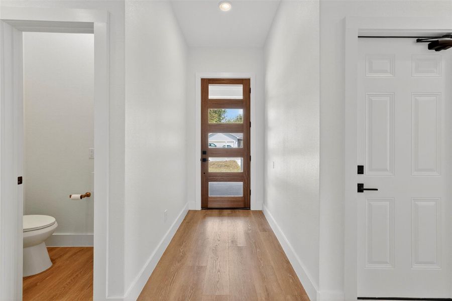 Entryway with wood finished floors and recessed lighting