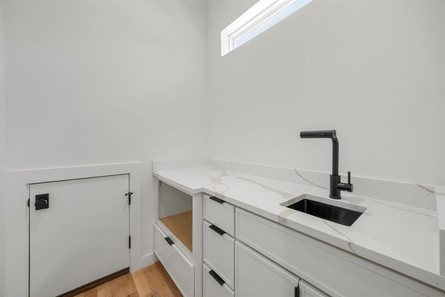 An extension of the kitchen, this thoughtfully designed prep area enhances both convenience and functionality with its own prep sink, additional cabinetry, and a dedicated space for a microwave. A convenient pass-through "Costco door" from the attached garage makes unloading groceries directly into the pantry and prep area effortless. An extension of the kitchen, this thoughtfully designed prep area enhances both convenience and functionality with its own prep sink, additional cabinetry, and a dedicated space for a microwave. A convenient pass-through "Costco door" from the attached garage makes unloading groceries directly into the pantry and prep area effortless.