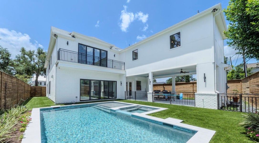 This modern two-story home features a spacious backyard with a pristine pool and spa, surrounded by lush greenery and a privacy fence. The covered patio offers a perfect outdoor entertaining space, seamlessly blending luxury and comfort.