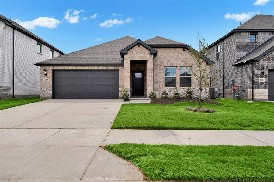 View of front of property featuring a shingled roof, a front lawn, driveway, and brick siding View of front of property featuring a shingled roof, a front lawn, driveway, and brick siding