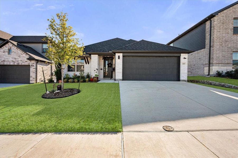 View of front of house with roof with shingles, concrete driveway, brick siding, an attached garage, and a front yard View of front of house with roof with shingles, concrete driveway, brick siding, an attached garage, and a front yard