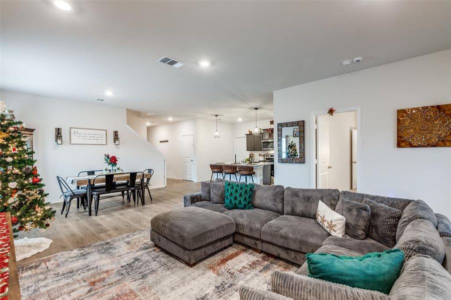 Living room featuring wood finished floors, recessed lighting, stairway, and a chandelier Living room featuring wood finished floors, recessed lighting, stairway, and a chandelier