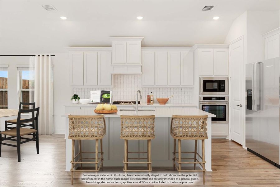 Kitchen with white cabinets, gray island, three wicker barstools, and stainless steel appliances on light hardwood floors Kitchen with white cabinets, gray island, three wicker barstools, and stainless steel appliances on light hardwood floors