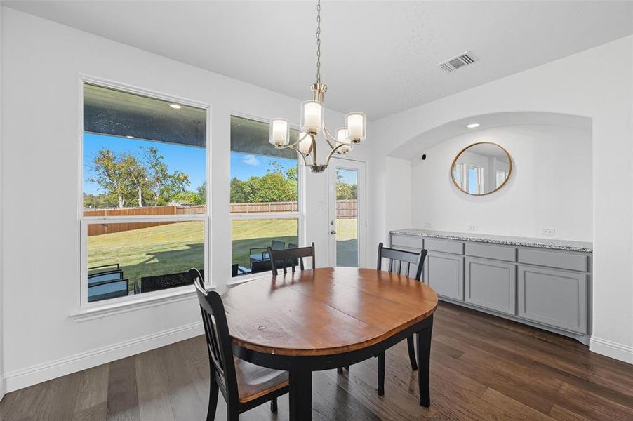 Dining room featuring dark wood-style floors and a chandelier