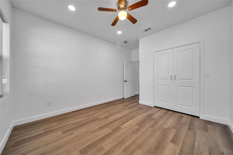 Unfurnished bedroom with light wood-type flooring, recessed lighting, ceiling fan, and a closet