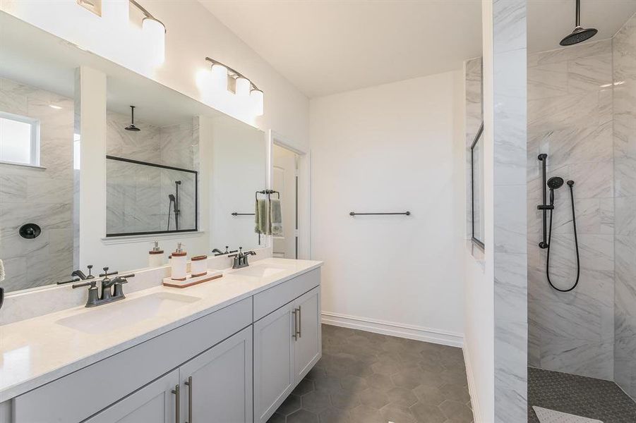 Bathroom with tile patterned flooring, vanity, and tiled shower