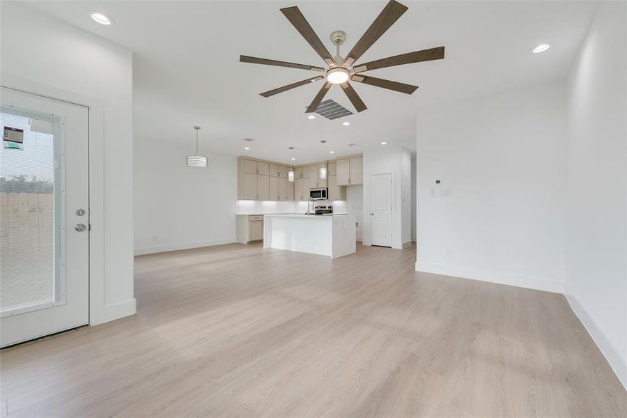 Unfurnished living room featuring recessed lighting, light wood-type flooring, and a ceiling fan Unfurnished living room featuring recessed lighting, light wood-type flooring, and a ceiling fan