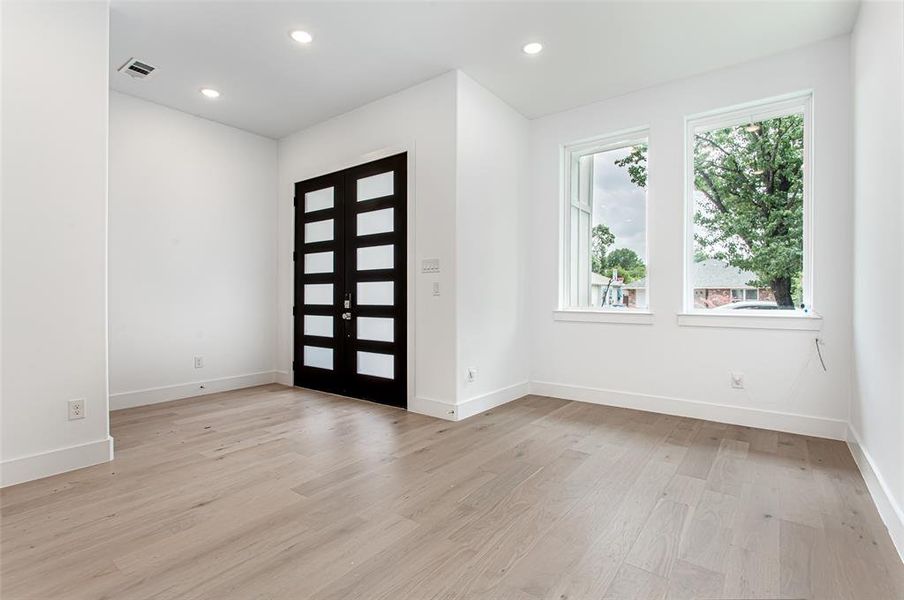 Foyer entrance featuring light wood finished floors, baseboards, recessed lighting, and french doors