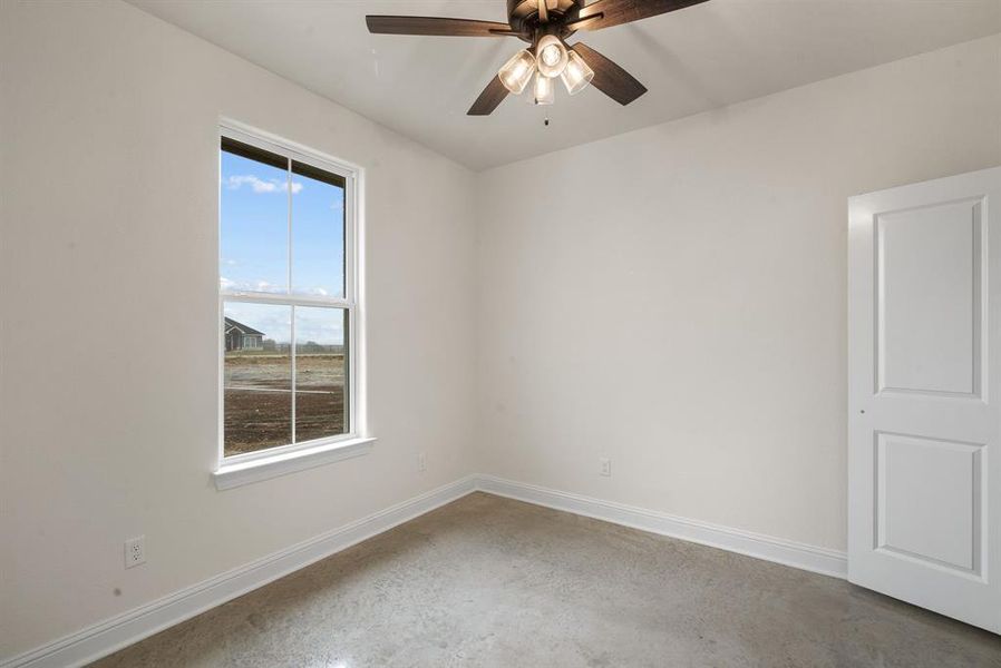 Empty room featuring ceiling fan and concrete floors