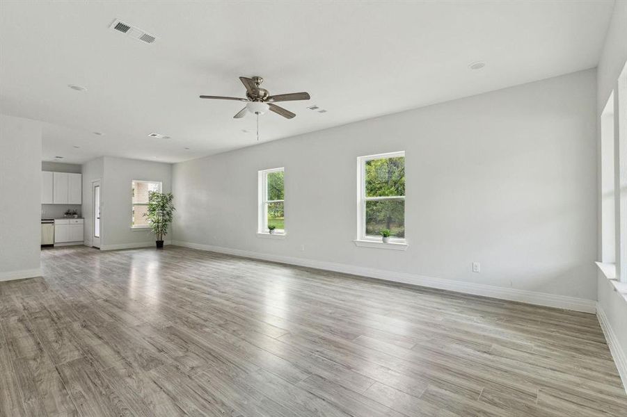 Unfurnished living room featuring light hardwood / wood-style flooring and ceiling fan