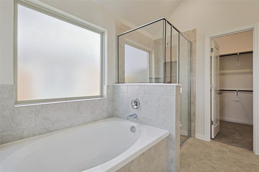 Bathroom with independent shower and bath and tile patterned flooring