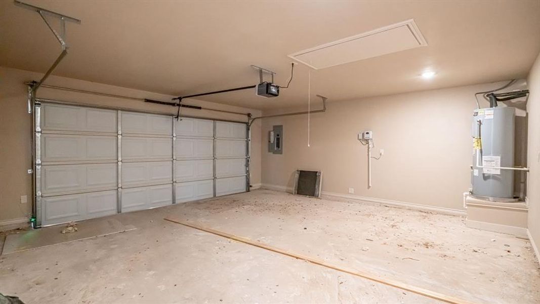 Garage featuring water heater and electric panel