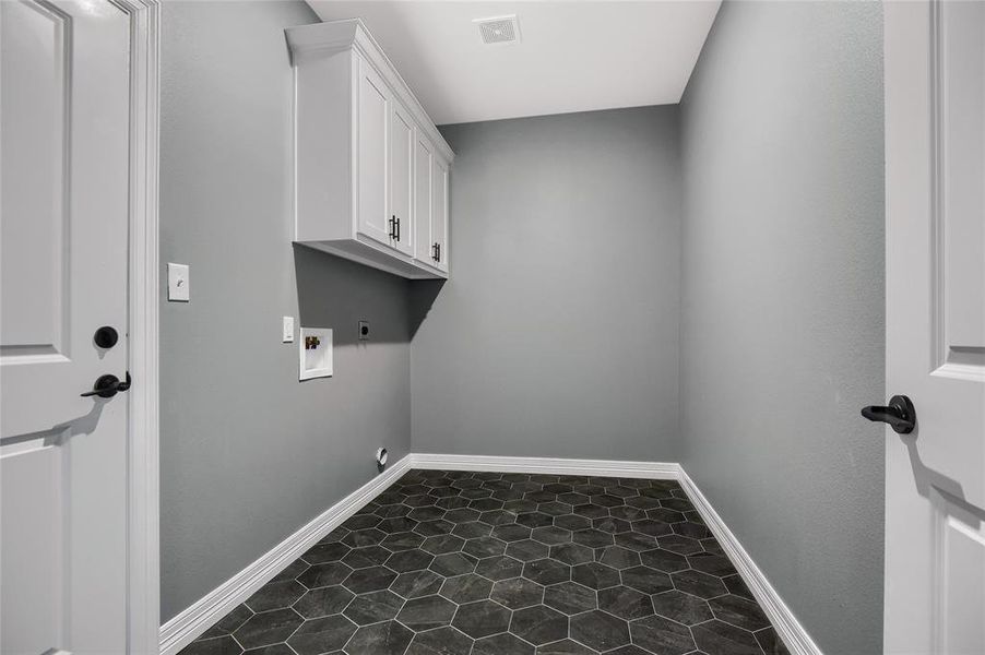 Laundry room with hookup for a washing machine, tile flooring, hookup for an electric dryer, and cabinets