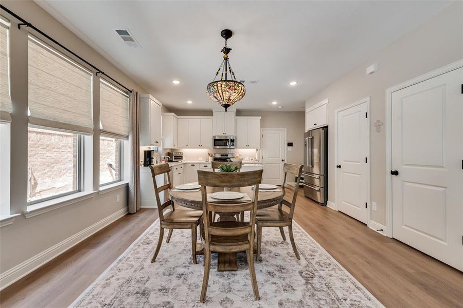 Dining area with light wood-type flooring and recessed lighting