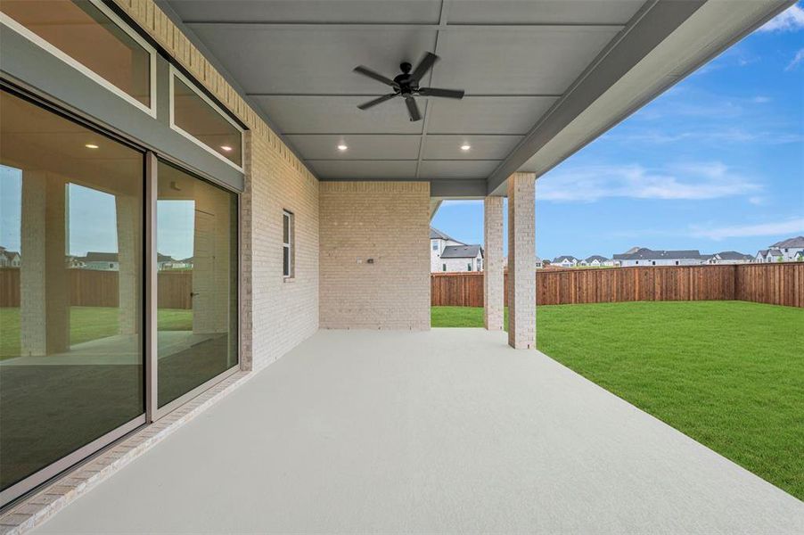 Fenced backyard with a ceiling fan, a patio, and a residential view