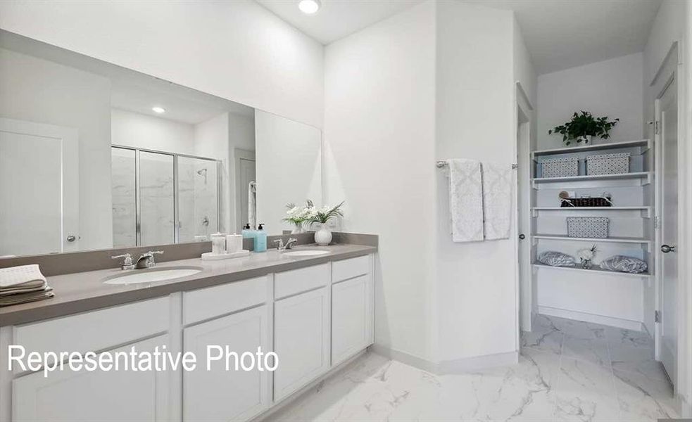 Bathroom featuring a shower with shower door and vanity