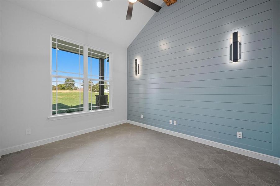 Unfurnished room featuring wooden walls and vaulted ceiling Unfurnished room featuring wooden walls and vaulted ceiling